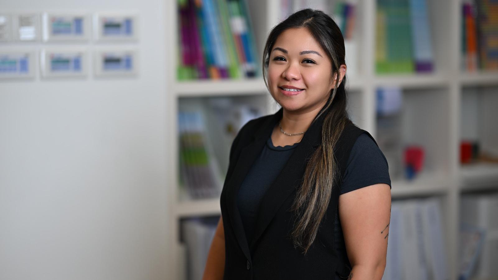 Christina Lo, English for Asia Trainer standing in front of a bookcase